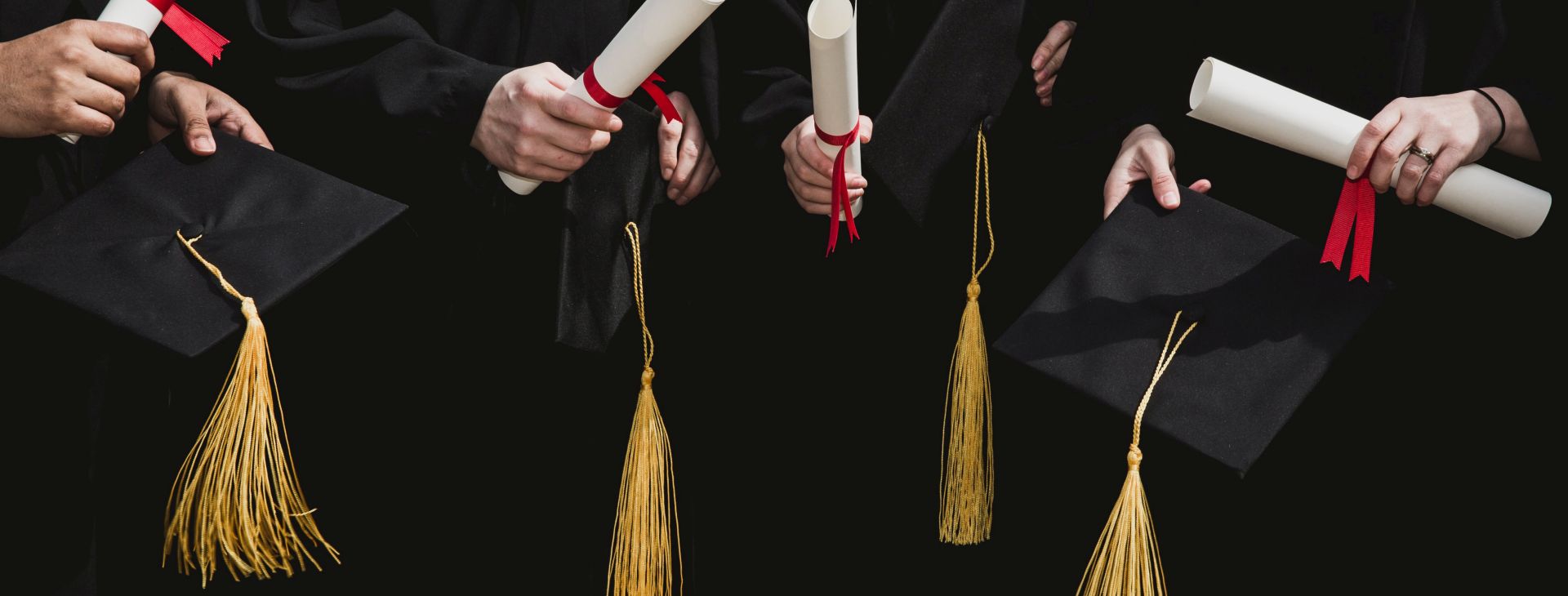 four-grad-students-caps-and-diplomas